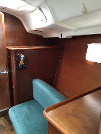 Sao Miguel Yacht Photos Pics Interior of 2000 Beneteau Oceanis 40 sailboat with wooden paneling and teal seating.