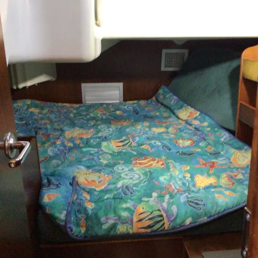 Sao Miguel Yacht Photos Pics Cozy cabin interior of 2000 Beneteau Oceanis 40 with colorful marine-themed bedding.