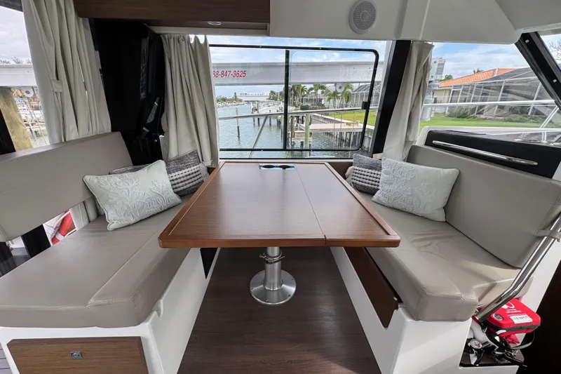  Yacht Photos Pics Interior of 2022 Jeanneau NC Weekender 1095 with cozy seating and waterfront view.