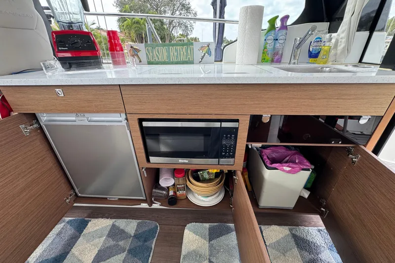  Yacht Photos Pics Kitchen area of 2022 Jeanneau NC Weekender 1095 with microwave and storage cabinets.
