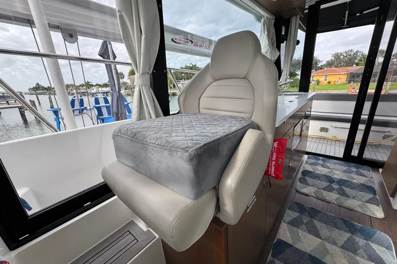  Yacht Photos Pics Interior of 2022 Jeanneau NC Weekender 1095 with cushioned seating and scenic marina view.
