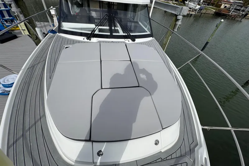  Yacht Photos Pics 2022 Jeanneau NC Weekender 1095 boat deck with cushioned seating, docked by the water.
