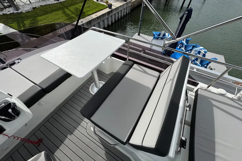  Yacht Photos Pics 2022 Jeanneau NC Weekender 1095 boat deck with seating and table, dockside view.