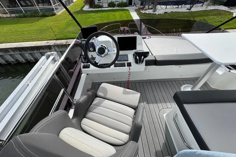  Yacht Photos Pics 2022 Jeanneau NC Weekender 1095 helm station with modern controls and seating.