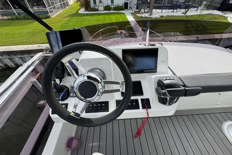  Yacht Photos Pics Steering console of 2022 Jeanneau NC Weekender 1095 with modern controls and navigation display.