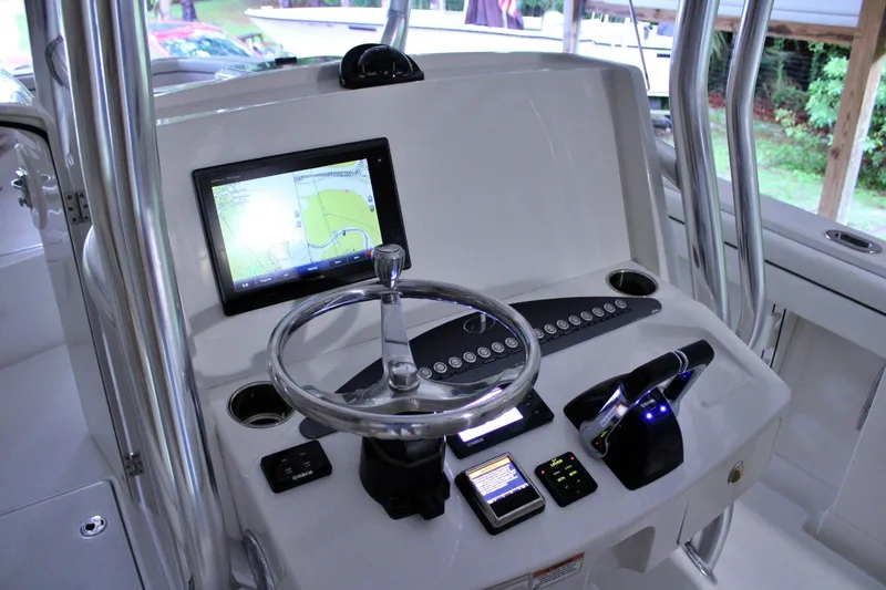  Yacht Photos Pics Control panel of a 2017 Jupiter 30 HFS boat with navigation screen and steering wheel.
