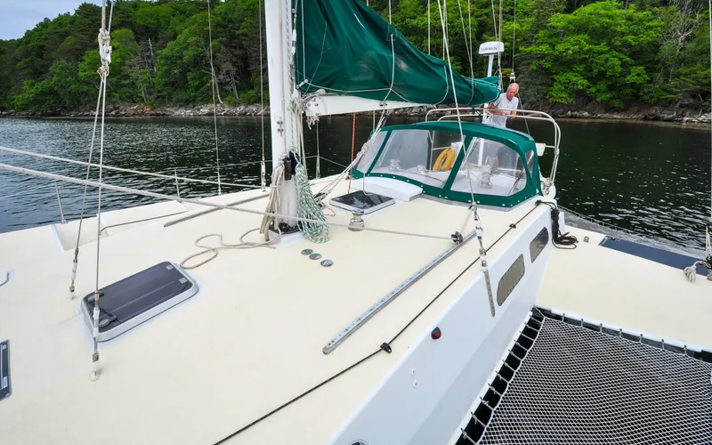 If Yacht Photos Pics Custom Marples CC 40 Fast Cruiser 2018 sailing in calm waters near lush green shoreline.