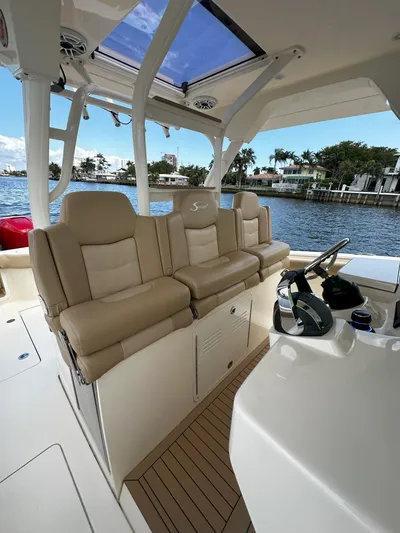  Yacht Photos Pics 2020 Scout 380 LXF boat interior with beige seating and helm, docked by waterfront homes.