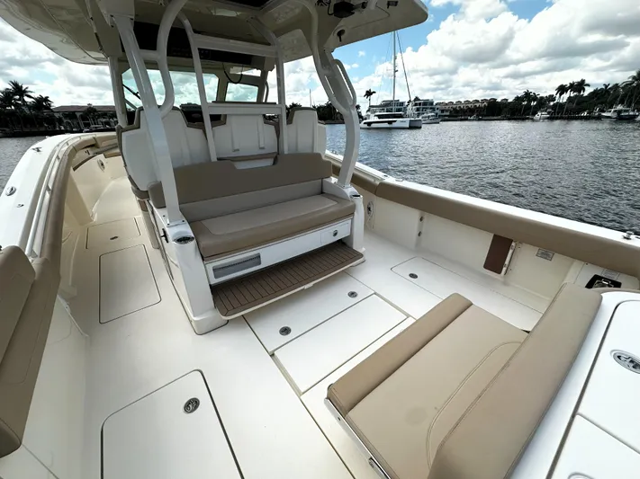  Yacht Photos Pics 2020 Scout 380 LXF boat interior with beige seating and open deck, docked by the water.