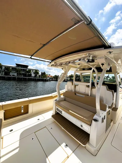  Yacht Photos Pics 2020 Scout 380 LXF boat with spacious seating and canopy, docked by waterfront homes.