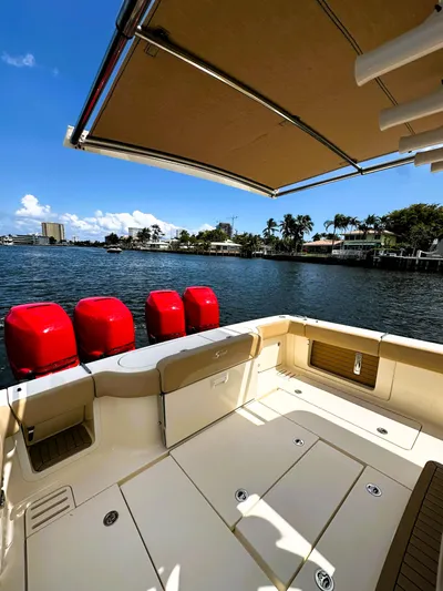  Yacht Photos Pics 2020 Scout 380 LXF boat with red engines, docked by a scenic waterfront.