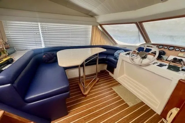  Yacht Photos Pics Interior of 2002 Navigator Classic 53 yacht with blue seating and wooden flooring.