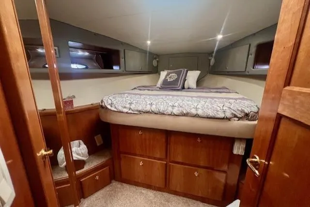  Yacht Photos Pics Cozy bedroom in 2002 Navigator Classic 53 yacht with wood cabinetry and plush bedding.