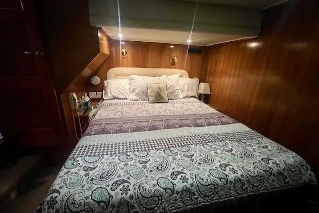  Yacht Photos Pics Luxurious bedroom in 2002 Navigator Classic 53 yacht with elegant wood paneling and cozy bedding.
