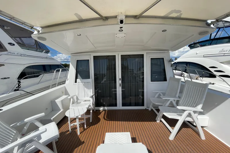  Yacht Photos Pics Deck of 2002 Navigator Classic 53 yacht with white chairs and sliding doors.