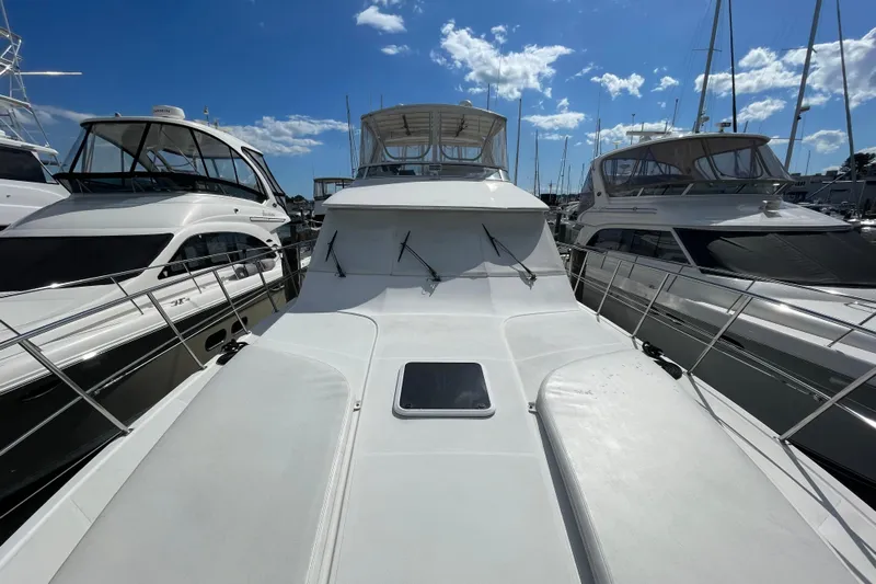 Yacht Photos Pics 2002 Navigator Classic 53 yacht docked between two boats under a clear blue sky.