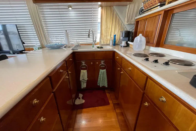  Yacht Photos Pics Kitchen area of a 2002 Navigator Classic 53 yacht with wooden cabinets and modern appliances.