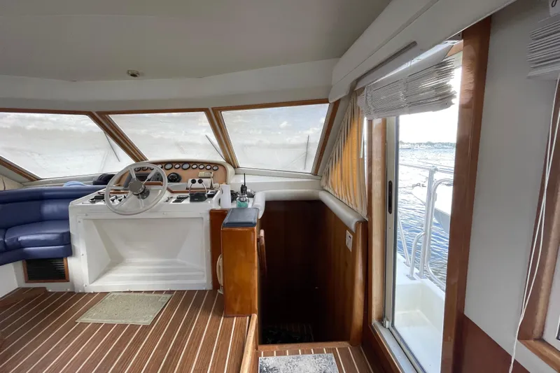  Yacht Photos Pics Interior of 2002 Navigator Classic 53 yacht with helm, blue seating, and ocean view.