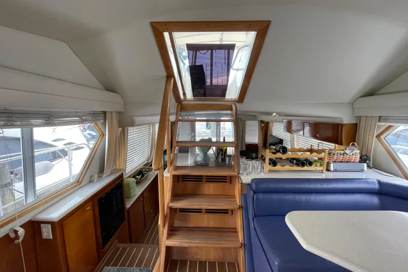  Yacht Photos Pics Interior of 2002 Navigator Classic 53 yacht with wooden stairs and blue seating.