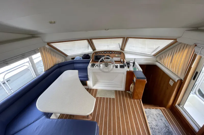  Yacht Photos Pics Interior of 2002 Navigator Classic 53 yacht with helm, seating, and wooden flooring.