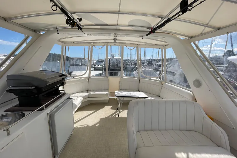  Yacht Photos Pics Luxurious interior of 2002 Navigator Classic 53 yacht with white seating and outdoor grill.