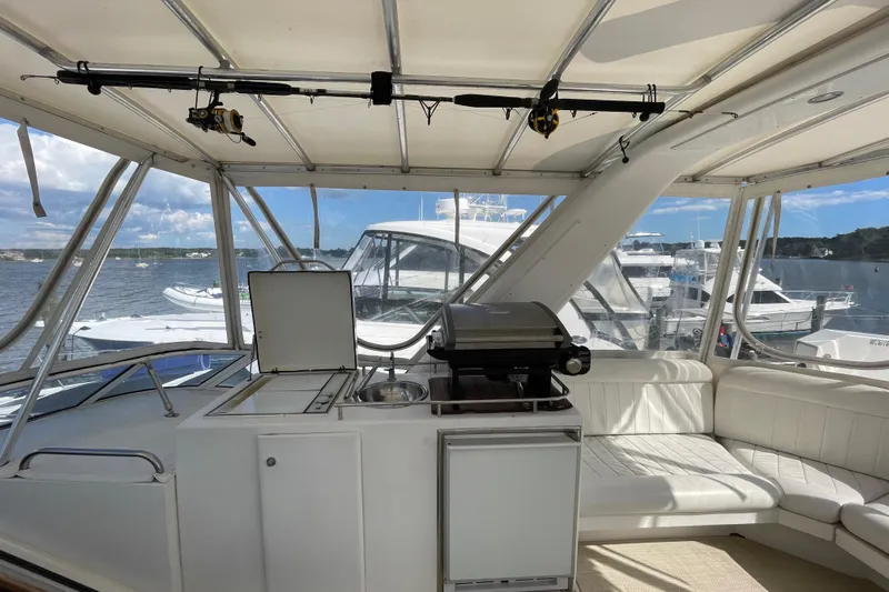  Yacht Photos Pics Interior of 2002 Navigator Classic 53 yacht with seating and grill, docked by the water.