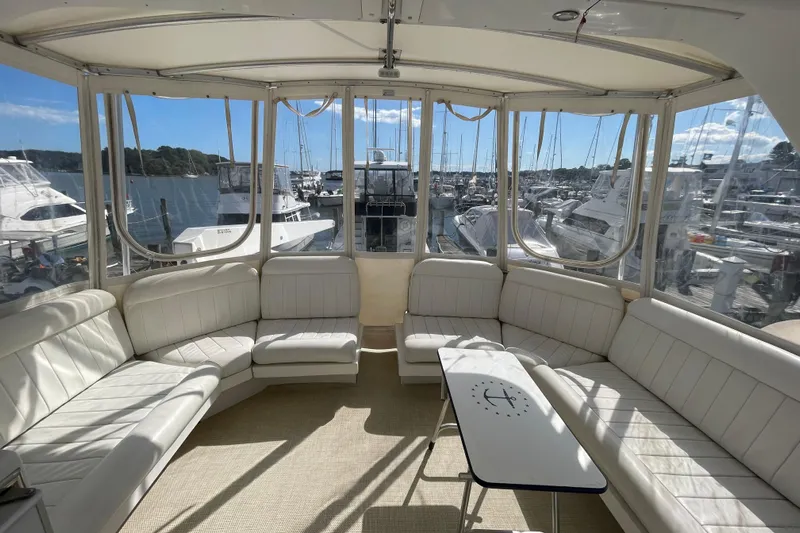  Yacht Photos Pics Luxurious 2002 Navigator Classic 53 yacht interior with white seating and marina view.