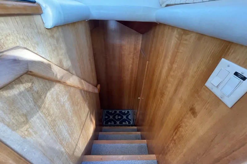  Yacht Photos Pics Staircase in 2002 Navigator Classic 53 yacht with wooden walls and nautical-themed rug.