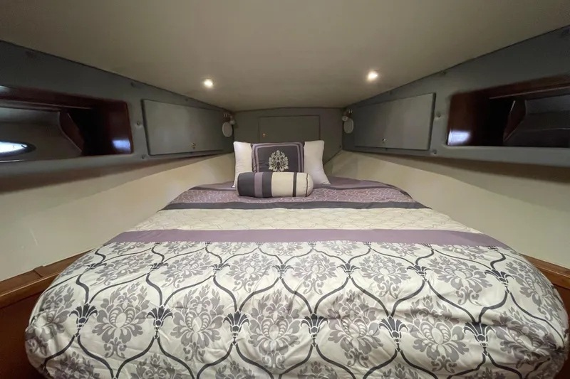  Yacht Photos Pics Cozy bedroom in 2002 Navigator Classic 53 yacht with elegant bedding and ambient lighting.