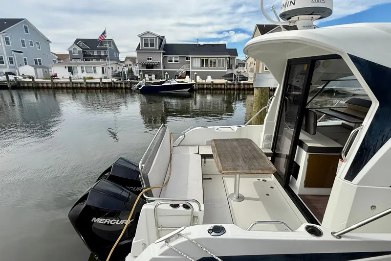  Yacht Photos Pics Beneteau Antares 9 (2021) docked, featuring outdoor seating and twin Mercury engines.