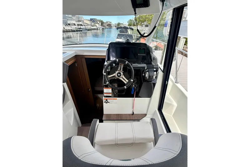 Yacht Photos Pics Interior view of 2021 Beneteau Antares 9 helm with steering wheel and navigation equipment.