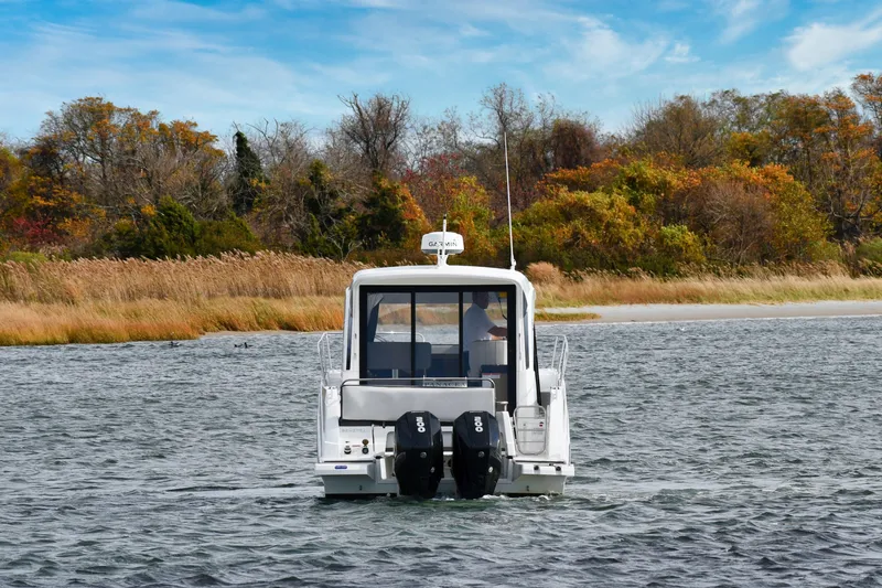  Yacht Photos Pics 2021 Beneteau Antares 9 boat cruising on a scenic lake with autumn foliage.