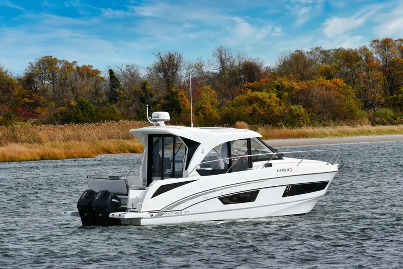  Yacht Photos Pics 2021 Beneteau Antares 9 boat cruising on a scenic lake with autumn foliage.