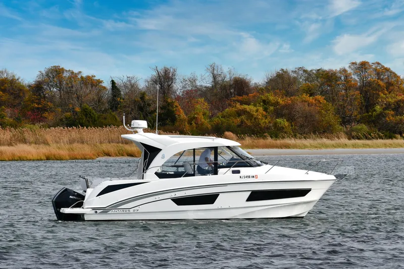  Yacht Photos Pics 2021 Beneteau Antares 9 boat on water with autumn trees in background.