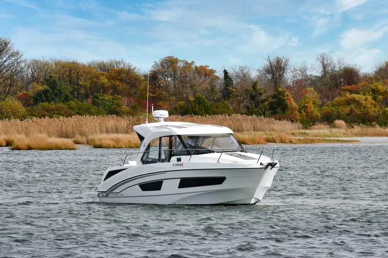  Yacht Photos Pics 2021 Beneteau Antares 9 boat on a scenic lake with autumn trees.