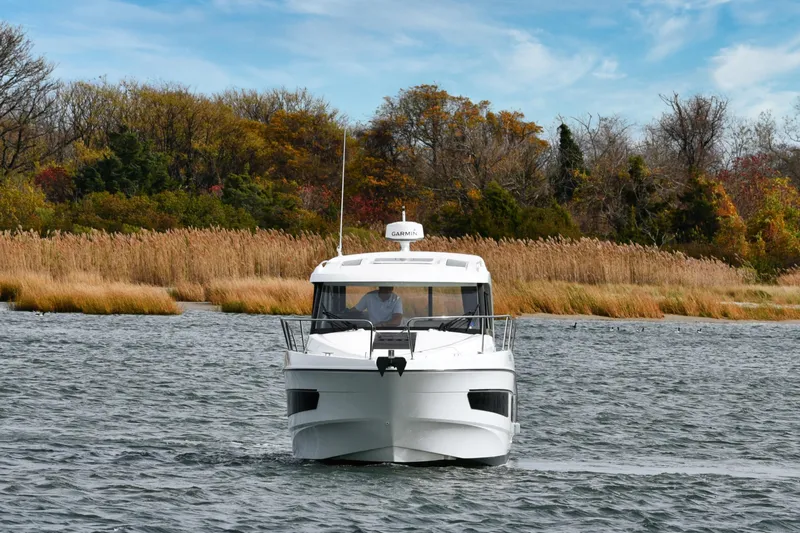  Yacht Photos Pics 2021 Beneteau Antares 9 cruising on a scenic river with autumn foliage.