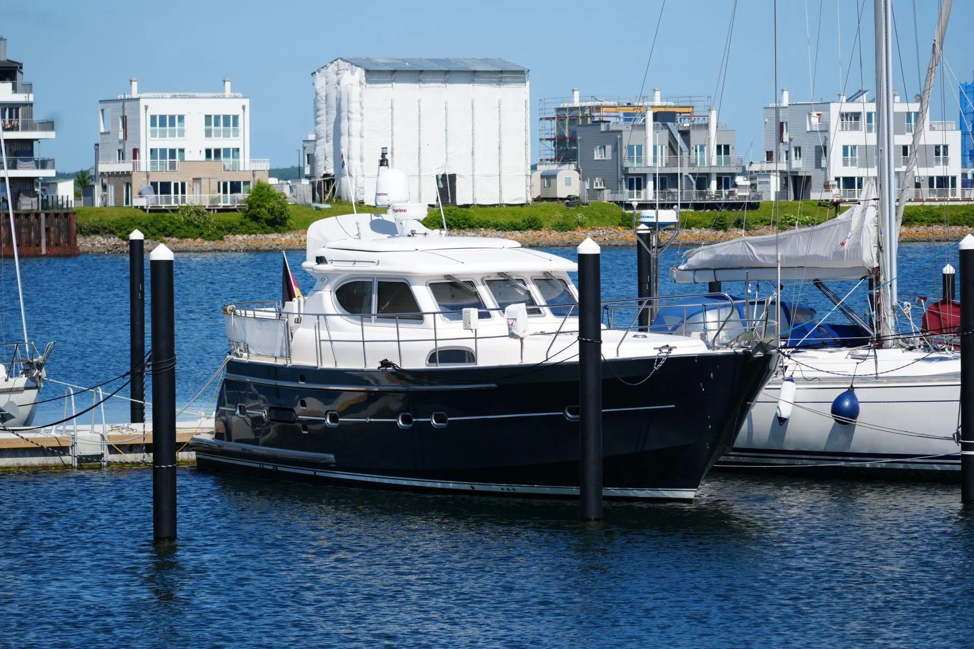 2016 Elling E3 Ultimate yacht docked in a marina with modern buildings in the background.