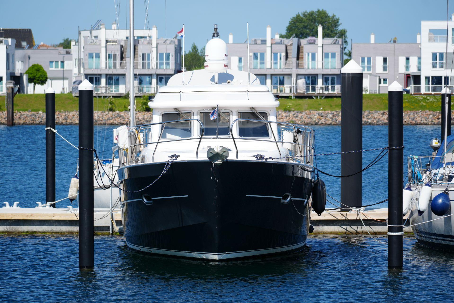 2016 Elling E3 Ultimate yacht docked in a marina with modern buildings in the background.