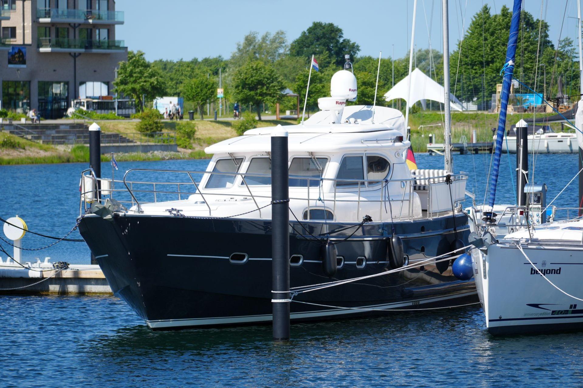 Elling E3 Ultimate 2016 yacht docked in a marina, surrounded by water and greenery.