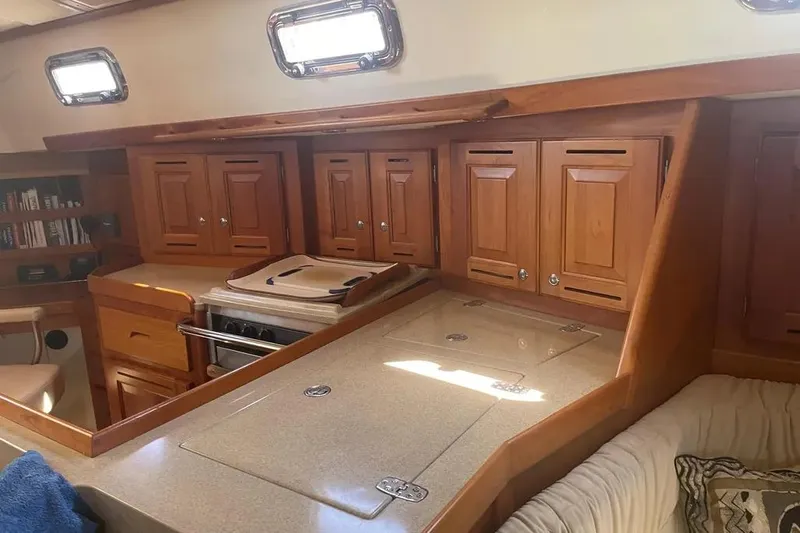 Mistral X Yacht Photos Pics Interior of 2009 Tartan 4300 sailboat with wooden cabinetry and cozy seating area.