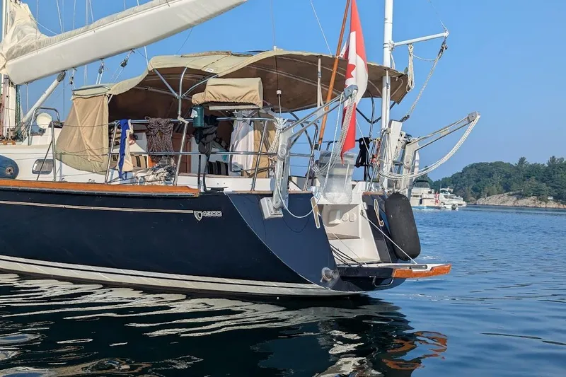 Mistral X Yacht Photos Pics Sailboat Tartan 4300, 2009 model, anchored in calm waters with scenic background.