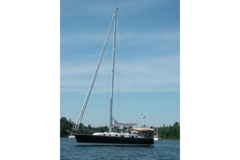 Mistral X Yacht Photos Pics 2009 Tartan 4300 sailboat on calm water under clear blue sky.