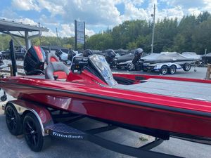 2025 Triton 21XP Patriot boat in vibrant red, parked outdoors under a partly cloudy sky.