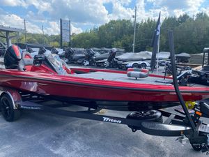 2025 Triton 21XP Patriot boat in vibrant red on a trailer, displayed outdoors.