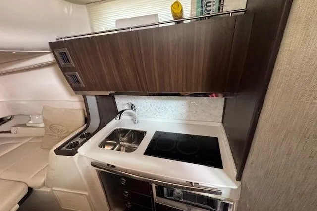  Yacht Photos Pics 2024 Grady-White Canyon 456 interior kitchen with sink, stove, and wooden cabinetry.