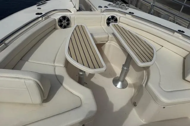  Yacht Photos Pics 2024 Grady-White Canyon 456 boat interior with cushioned seating and wooden tables.