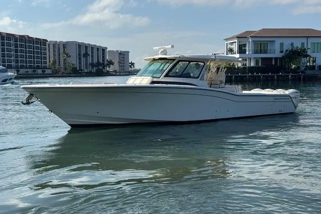  Yacht Photos Pics 2024 Grady-White Canyon 456 boat on water near waterfront buildings.