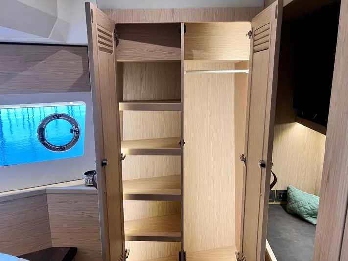  Yacht Photos Pics Open wooden closet with shelves in the 2025 Beneteau Swift Trawler 54 yacht.