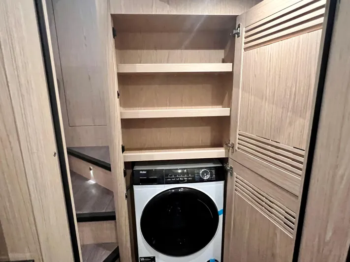  Yacht Photos Pics Laundry area with washer and storage shelves in 2025 Beneteau Swift Trawler 54.