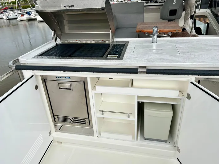  Yacht Photos Pics Outdoor kitchen on 2025 Beneteau Swift Trawler 54 with grill, sink, and storage.